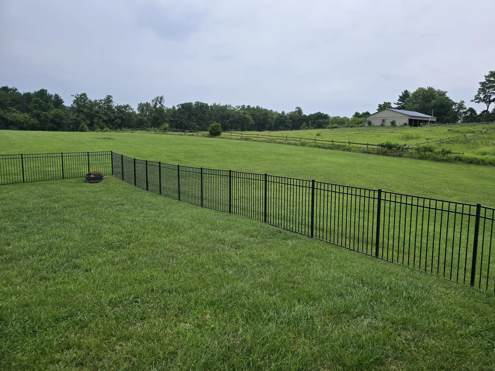 Black aluminum fence installed across an open Maryland property