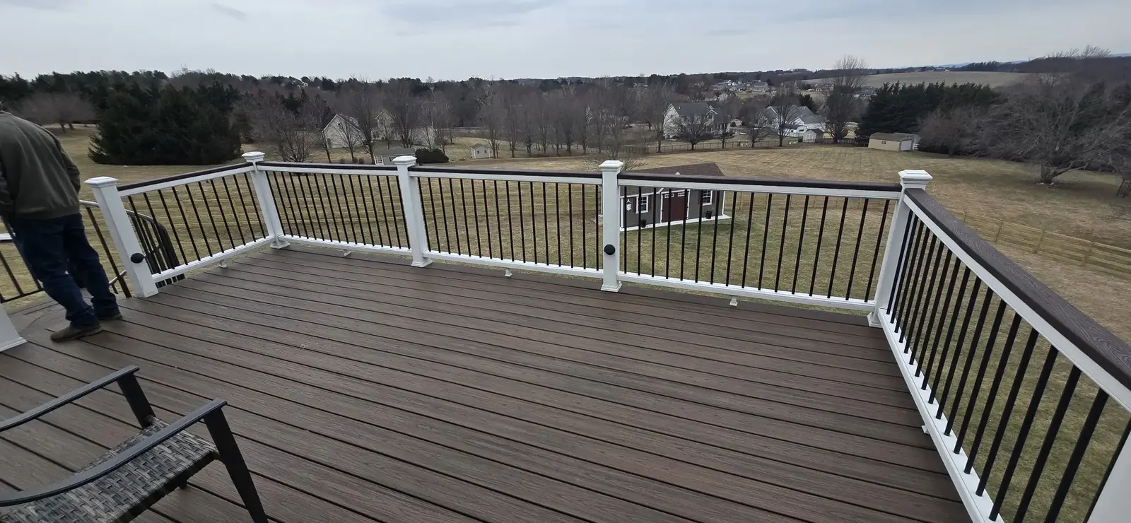 Composite deck with white posts and dark balusters overlooking a Maryland hillside